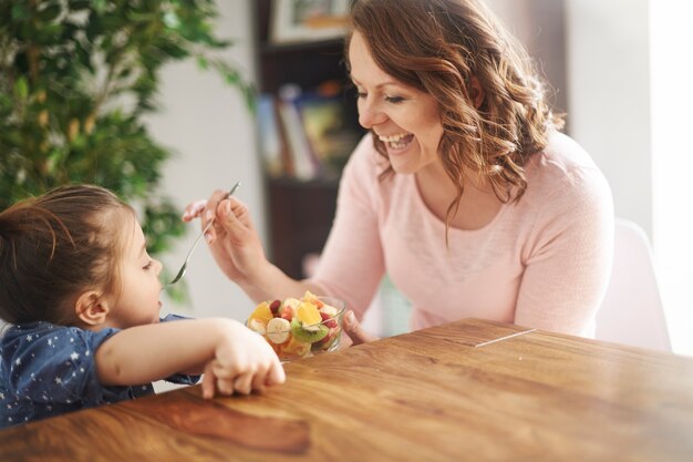 Vrouw die fruit geeft aan haar dochter