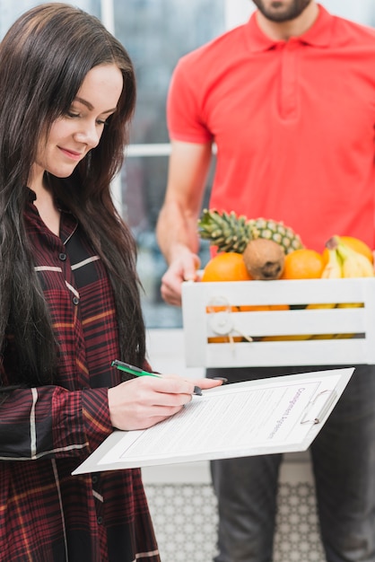 Vrouw die fruitlevering bevestigt