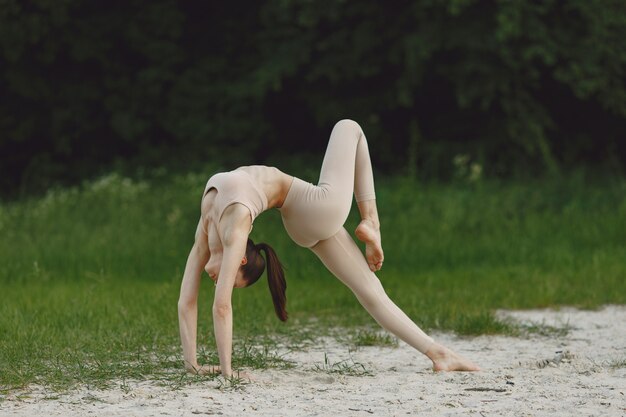 Vrouw die geavanceerde yoga in een strand uitoefenen