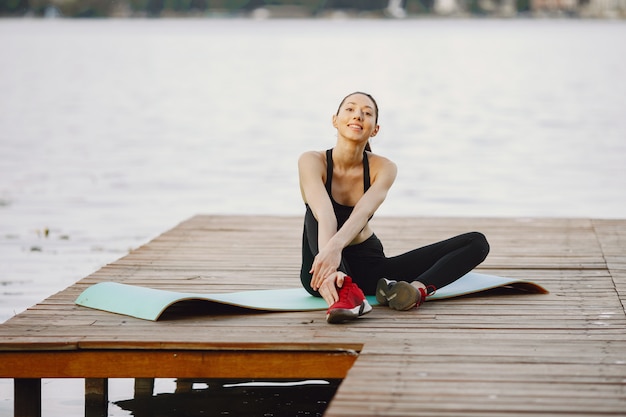 Vrouw die geavanceerde yoga uitoefenen door het water