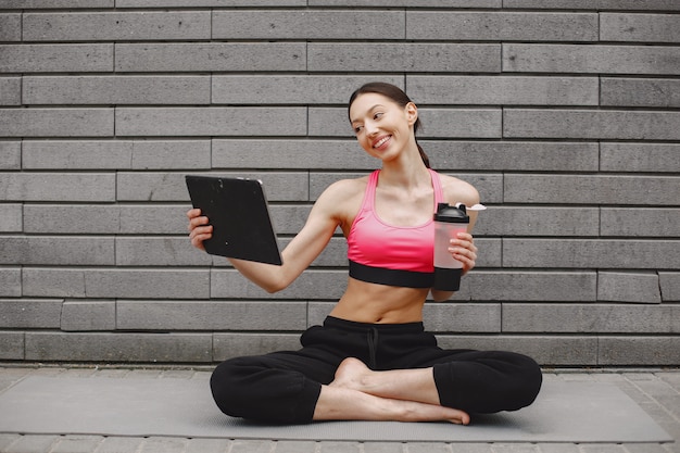 Vrouw die geavanceerde yoga uitoefenen tegen een donkere stedelijke muur