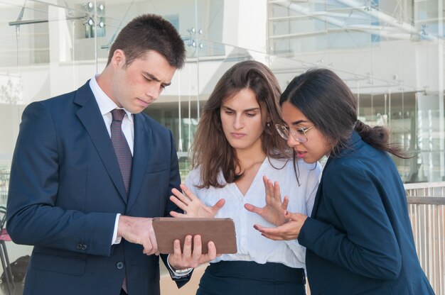 Vrouw die gegevens over tablet toont, iedereen die sceptisch kijkt