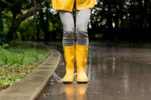 Gratis foto vrouw die gele regenlaarzen draagt