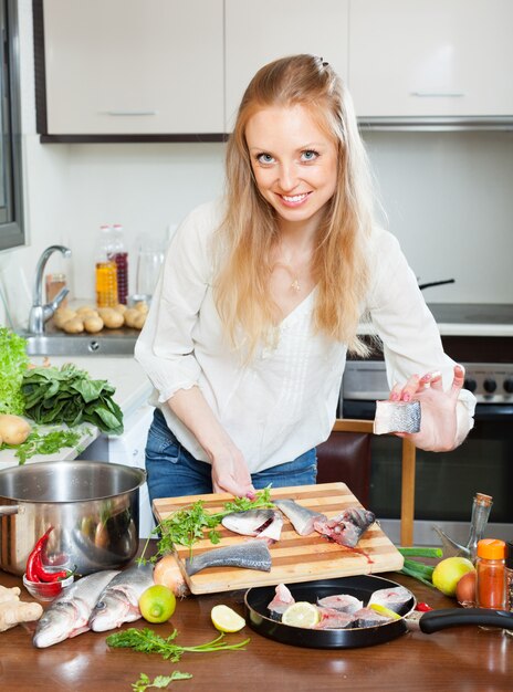 Gratis foto vrouw die gesneden vis in de pan plaatst