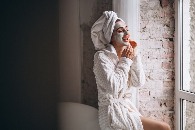 Vrouw die gezichtsmasker in een badkamers toepast