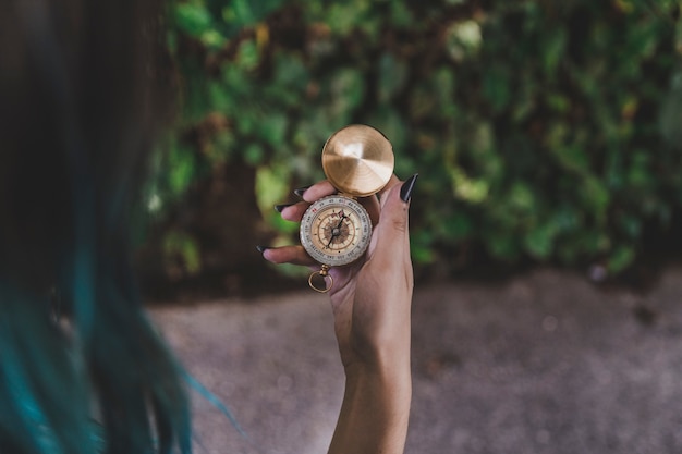 Vrouw die gouden uitstekend kompas in hand bekijkt