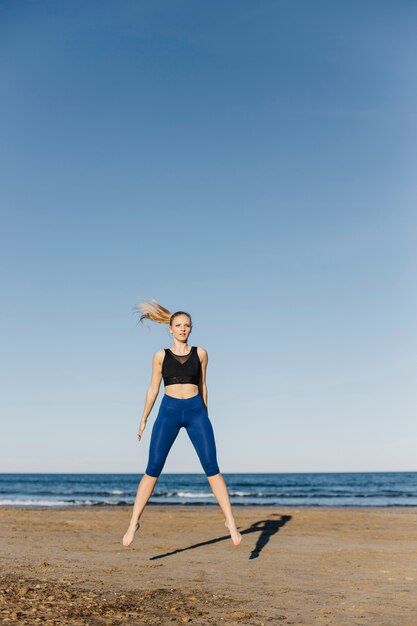 Vrouw die gymnastiek doet bij het strand