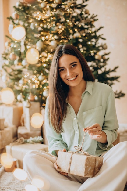 Vrouw die haar cadeau opent met kerstmis