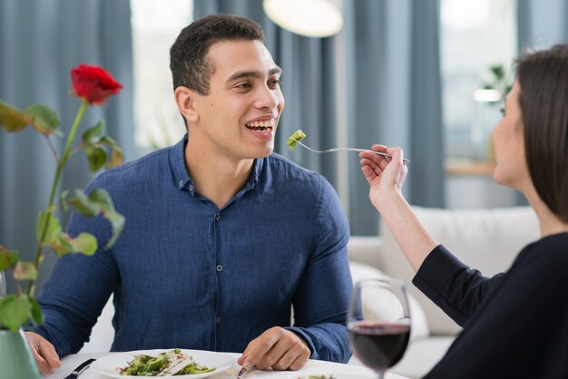 Vrouw die haar echtgenoot voedt bij een romantisch diner