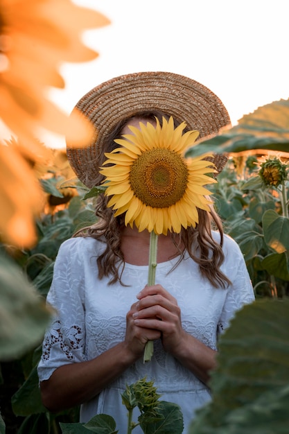 Vrouw die haar gezicht behandelt met zonnebloem