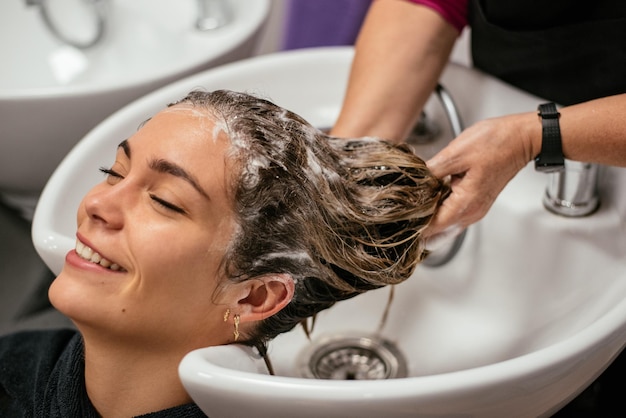 Vrouw die haar haar heeft dat in een salon wordt gewassen