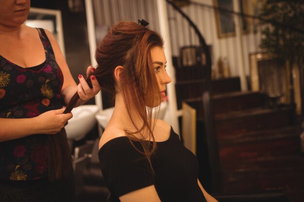 Vrouw die haar haar stileert bij salon