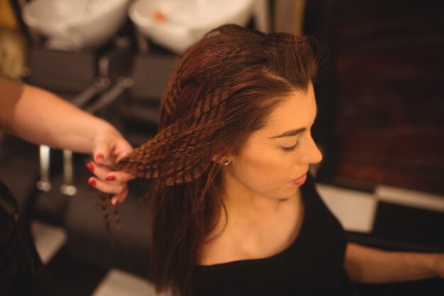 Vrouw die haar haar stileert bij salon