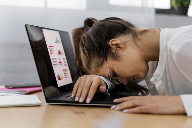 Vrouw die haar hoofd op laptop rust