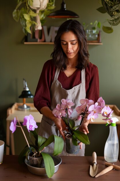 Vrouw die haar huis versierd met orchideeën