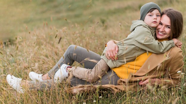 Vrouw die haar jongen in het gras koestert