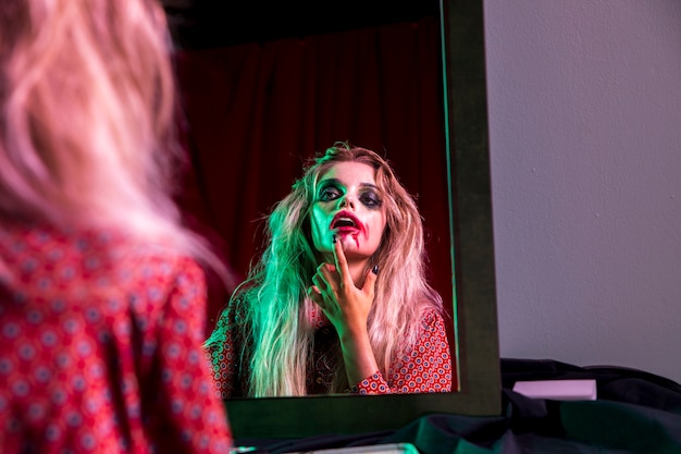 Vrouw die haar lippenstift bevestigt voor Halloween-nacht