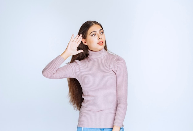 Vrouw die haar oor wijst omdat ze niet goed kan horen.