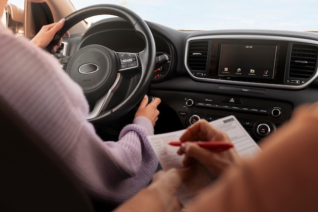 Gratis foto vrouw die haar rijbewijs in een voertuig aflegt