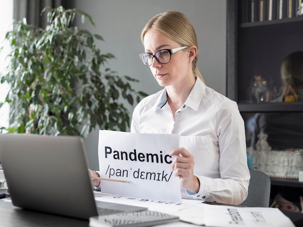 Gratis foto vrouw die haar studenten de definitie van pandemie online leert