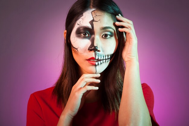 Vrouw die Halloween masker draagt ​​en haar hoofd aanraakt
