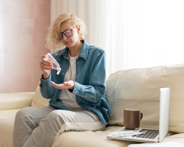 Vrouw die handdesinfecterend middel gebruikt