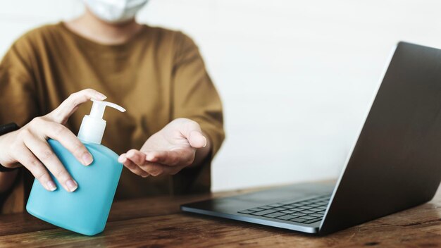 Vrouw die handen schoonmaakt met een handdesinfecterende gel om besmetting met het coronavirus te voorkomen