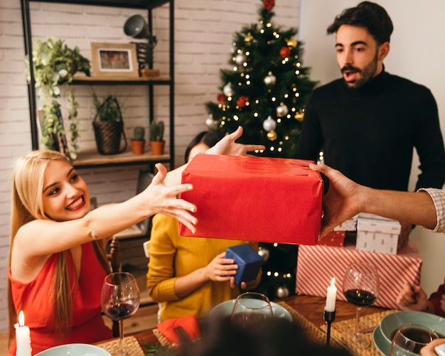 Gratis foto vrouw die heden ontvangt bij kerstmisdiner