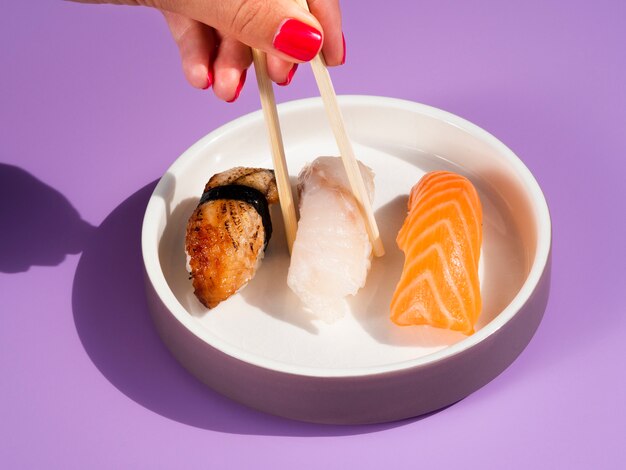 Vrouw die heerlijke sushi van een plaat met sushi neemt