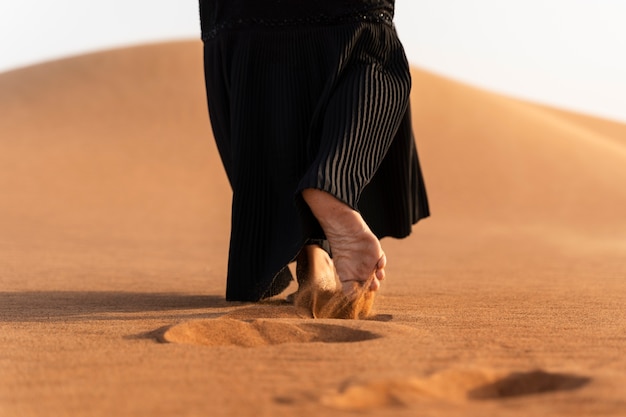 Vrouw die hijab draagt in de woestijn