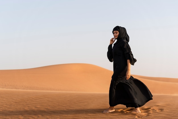 Vrouw die hijab draagt in de woestijn