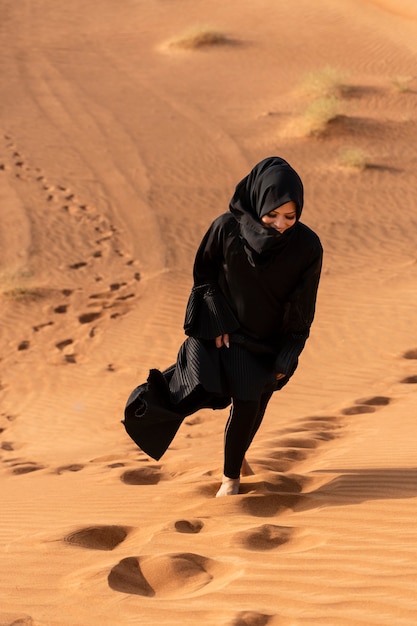 Vrouw die hijab draagt in de woestijn