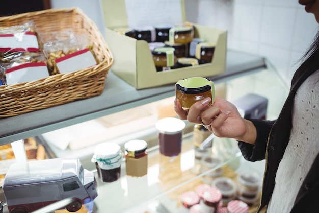 Vrouw die honing selecteert bij voedselteller