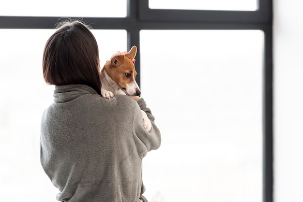 Gratis foto vrouw die in badjas haar hond met exemplaarruimte houdt