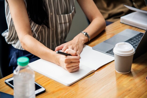 Vrouw die in een notitieboekje schrijft