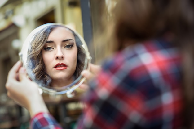 Gratis foto vrouw die in een spiegel