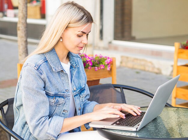 Vrouw die in openlucht aan laptop werkt