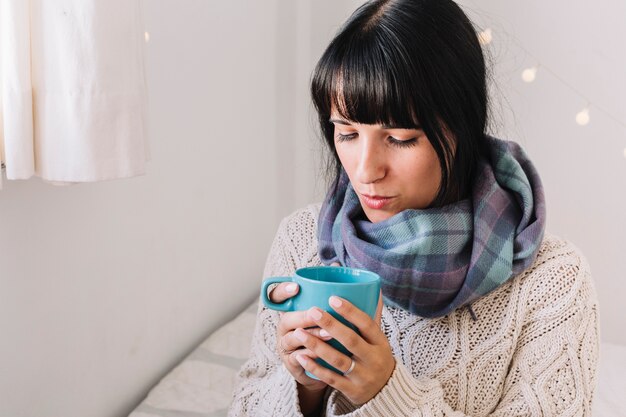 Vrouw die in sweater op kop blaast