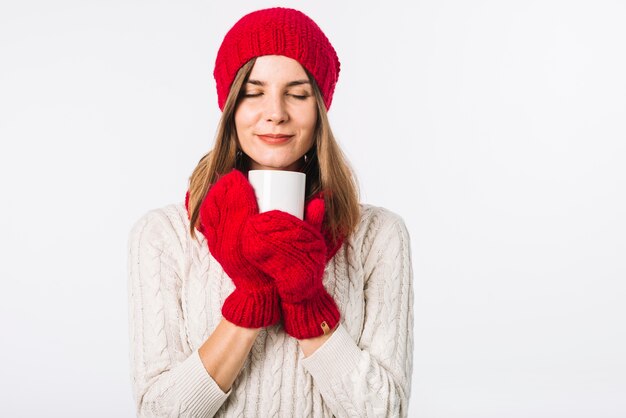 Vrouw die in sweater warme kop houdt