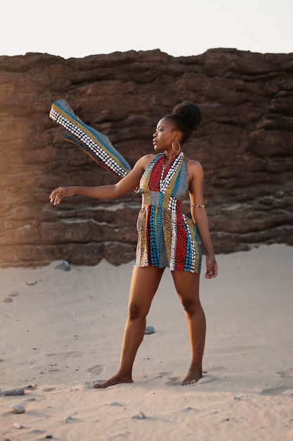 Vrouw die inheemse Afrikaanse kleding draagt bij het strand