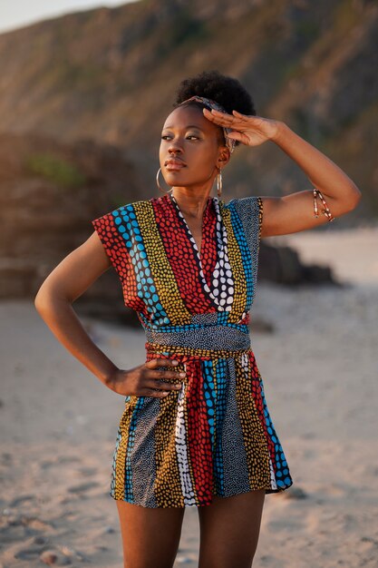 Vrouw die inheemse Afrikaanse kleding draagt bij het strand