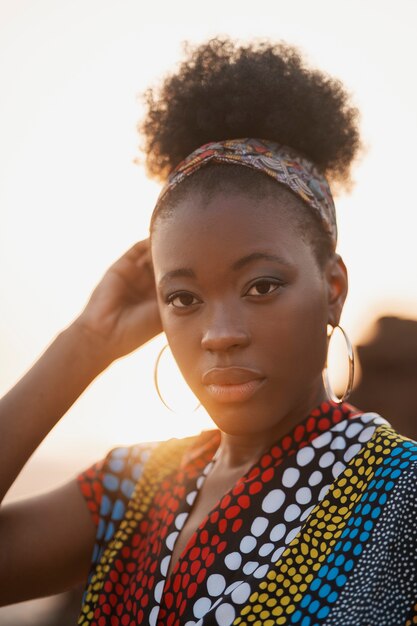 Vrouw die inheemse Afrikaanse kleding draagt bij zonsondergang op het strand