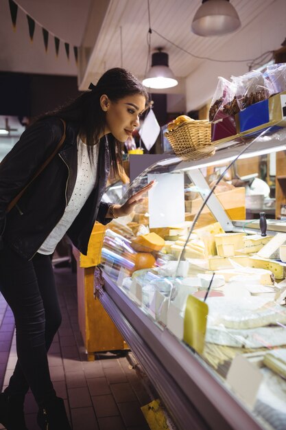 Vrouw die kaasvertoning bekijkt