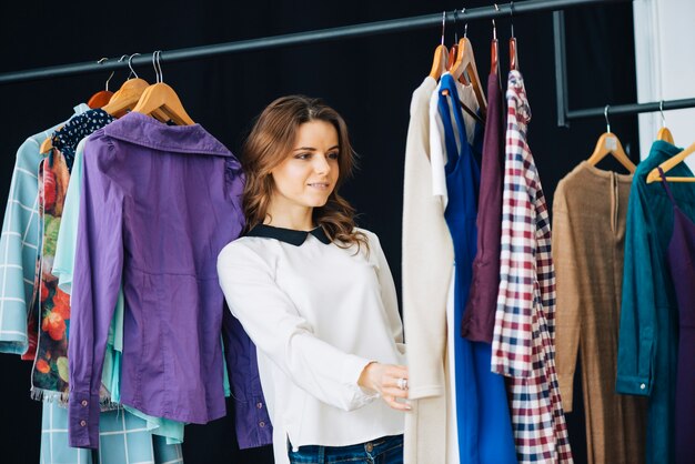 Vrouw die kleding op klerenspoor bekijkt