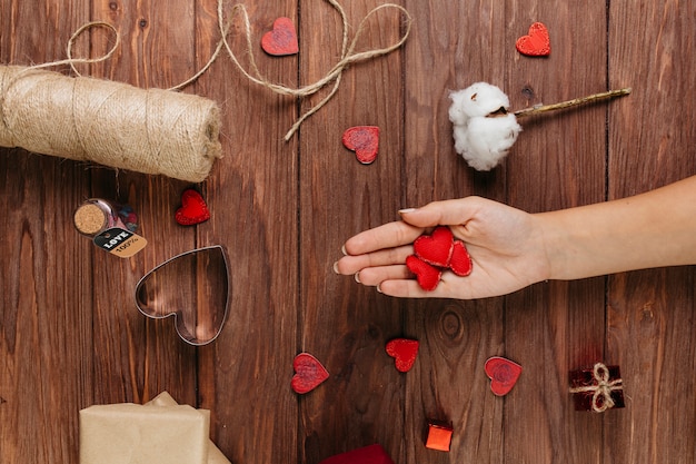 Vrouw die kleine harten in hand houdt