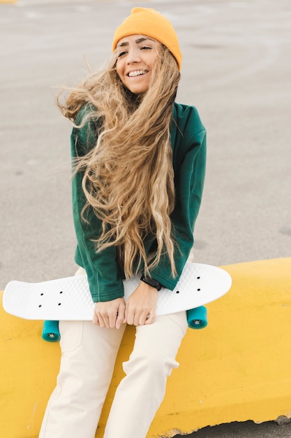 Gratis foto vrouw die lacht met skateboard