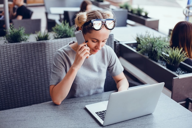 Vrouw die laptop in een koffie met behulp van