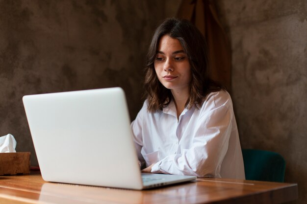 Vrouw die laptop in koffiewinkel bekijkt