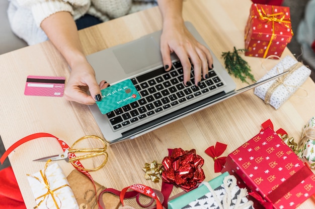 Vrouw die laptop met creditcard met behulp van