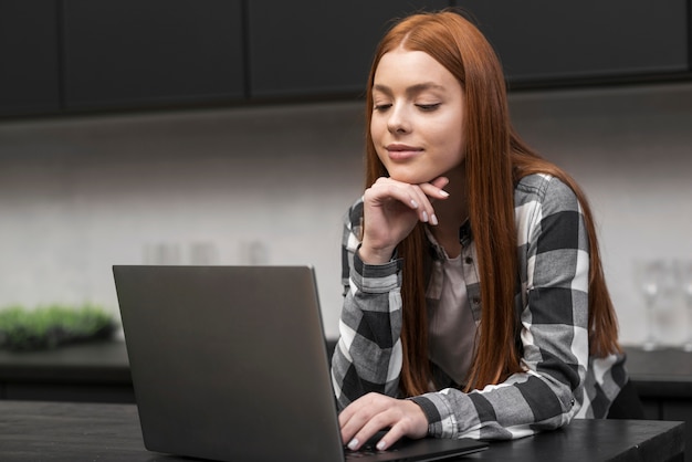 Vrouw die laptop middelgroot schot controleert